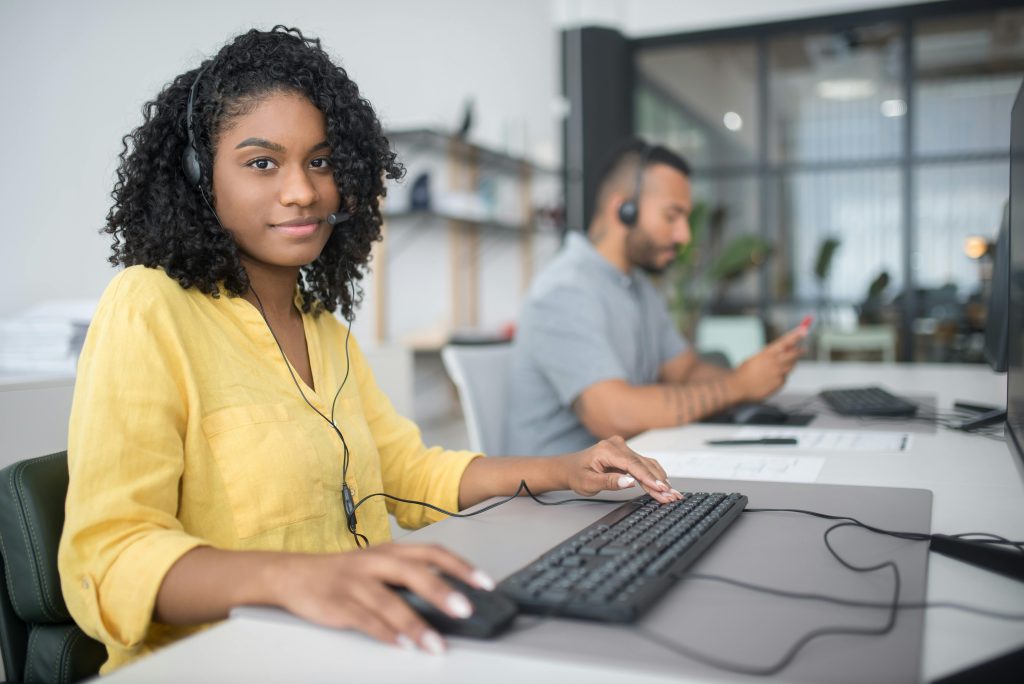 Two professionals working at a call center in Portugal, providing customer service through headsets.